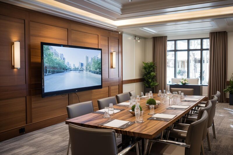 Ljust konferensrum med stort bord och dagsljus.